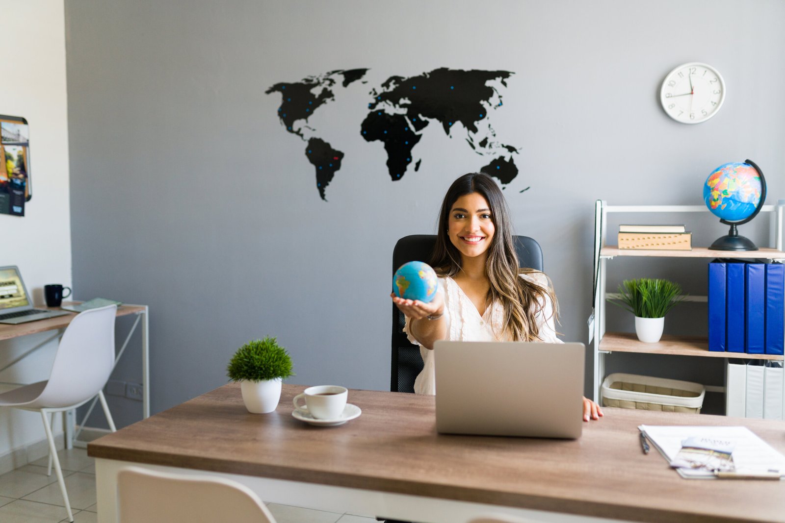 holding world my hands attractive female travel agent showing globe smiling while working her modern office scaled